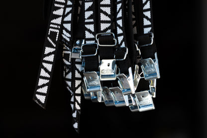 Black and white patterned belt with reflective silver buckle on a black background